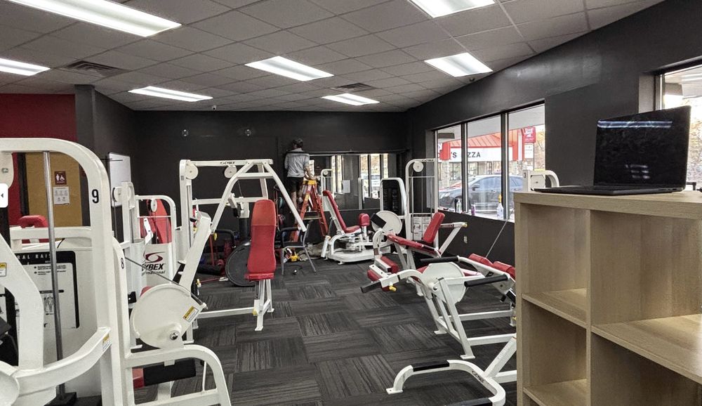 Fitness studio interior painted in dark charcoal, with work in progress on the far wall