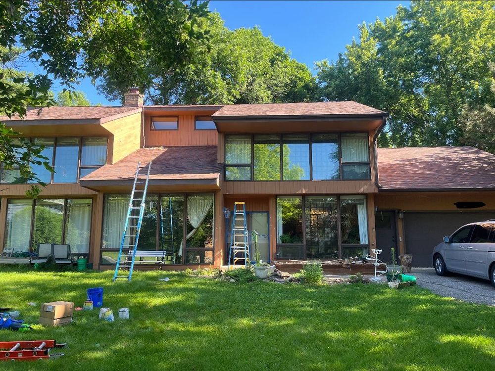 House exterior before painting, with natural cedar-tone siding