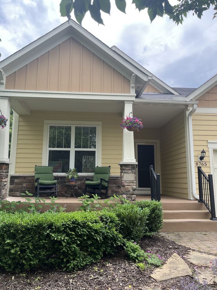 Yellow craftsman-style front porch with white board-and-batten trim