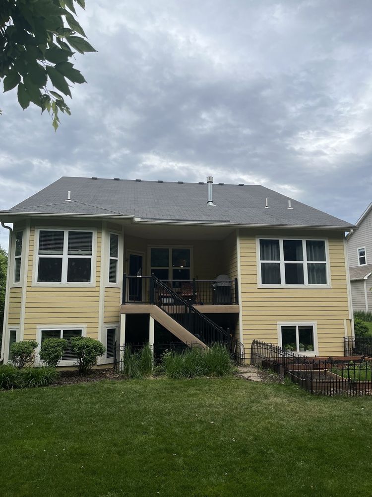 Rear of a yellow home with a freshly finished raised deck