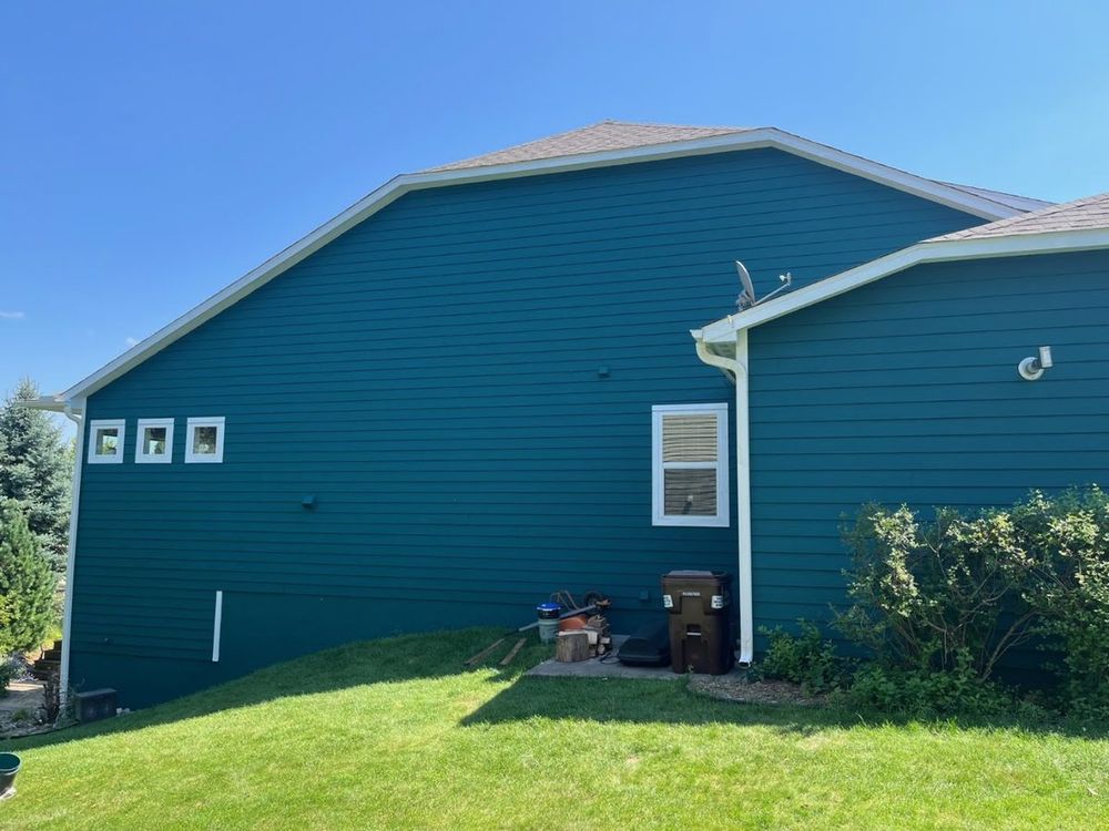 Teal-green gable end with crisp white trim after exterior painting