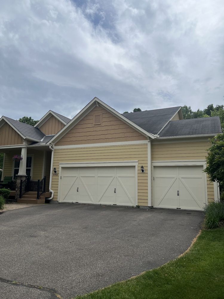 Freshly painted yellow home exterior with white trim and garage