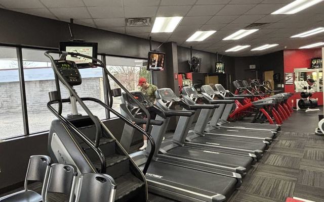 Charcoal and red interior walls behind a row of cardio machines